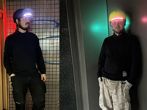 Zwei Männer mit leuchtenden Lumos-Helmen in dunkler Umgebung